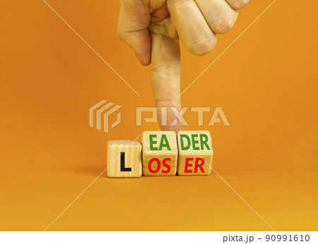 Loser or leader symbol. Concept words Loser or leader on wooden cubes. Businessman hand. Beautiful orange table orange background. Business and loser or leader concept. Copy space. 90991610