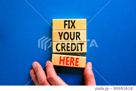Fix your credit here symbol. Concept words Fix your credit here on wooden blocks on a beautiful blue table blue background. Businessman hand. Business, finacial and fix your credit here concept. Fix your credit here symbol. Concept words Fix your credit here on wooden blocks on a beautiful blue table blue background. Businessman hand. Business, finacial and fix your credit here concept. 90991618