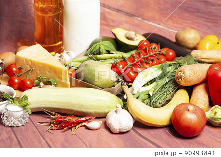 Healthy food selection with fruits,vegetables,cheese,nuts, milk,spices,olive oil on wooden background 90993841