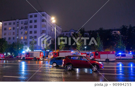 Fire engines in the courtyard of the apartment building where the fire occurred, at night during the rain. Fire engines in the courtyard of the apartment building where the fire occurred, at night during the rain. 90994255