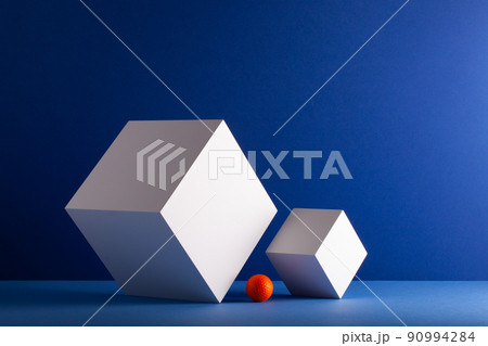 Two cubes with orange golf ball on the blue background. Two cubes with orange golf ball on the blue background. 90994284