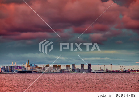 Magic pink sky over the residential complex under construction on the embankment of the Neva River on Vasilievsky island in sunset, bulk island, construction cranes Magic pink sky over the residential complex under construction on the embankment of the Neva River on Vasilievsky island in sunset, bulk island, construction cranes 90994788