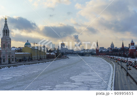 Cars on the Kremlin embankment and the frozen Moscow river on a clear winter day. 90995655