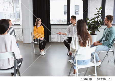 Psychotherapist working with patients in group therapy session indoors Psychotherapist working with patients in group therapy session indoors 90996171