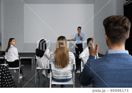 Male business trainer giving lecture in conference room with projection screen 90996173