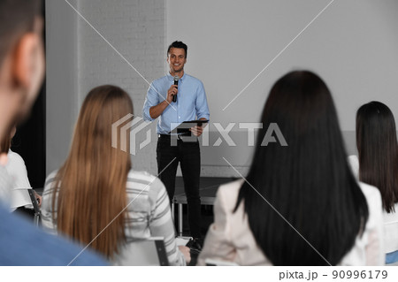 Male business trainer giving lecture in conference room with projection screen 90996179