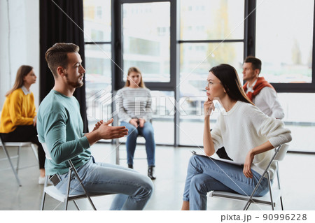 Psychotherapist working with patient in group therapy session indoors Psychotherapist working with patient in group therapy session indoors 90996228