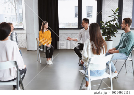 Psychotherapist working with patients in group therapy session indoors 90996232