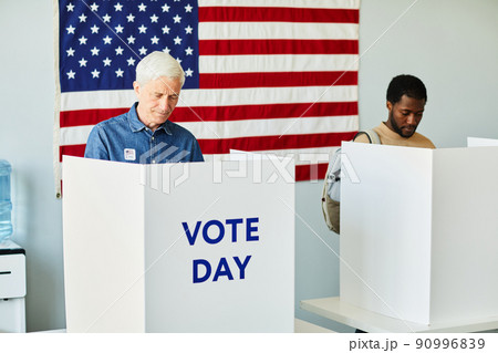 Senior Man Voting in Booth Senior Man Voting in Booth 90996839