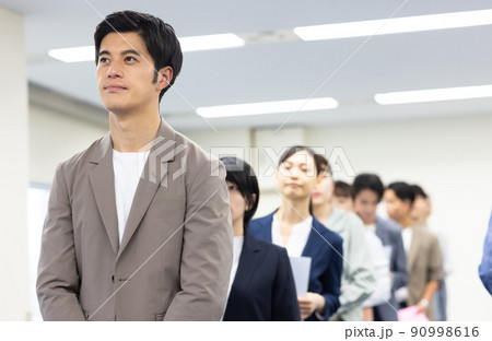 順番を待つ一列に並ぶ男女 90998616