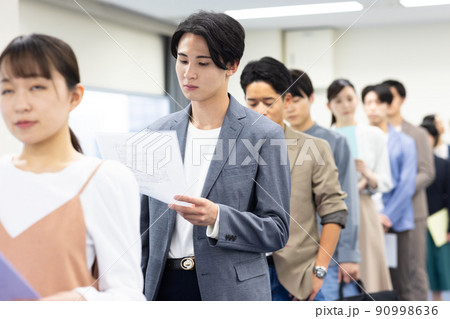 順番を待つ一列に並ぶ男女 90998636