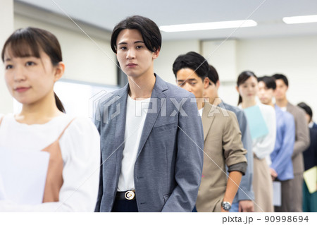 順番を待つ一列に並ぶ男女 順番を待つ一列に並ぶ男女 90998694