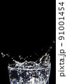 Splashing water on glass on isolated black background 91001454