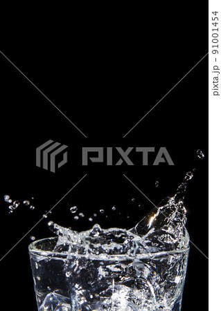 Splashing water on glass on isolated black background 91001454