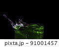Water splashed from the mouth of the green glass. 91001457