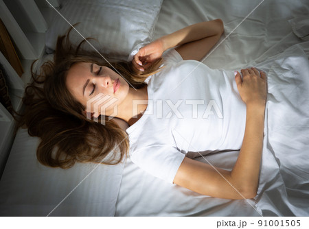 Portrait of blond girl with long hair sleeping in bed 91001505