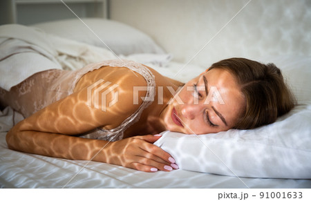 Portrait of blond girl with long hair sleeping in bed 91001633