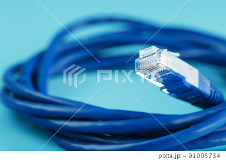 A coil of an Internet network cable for data transmission on a blue background A coil of an Internet network cable for data transmission on a blue background 91005734
