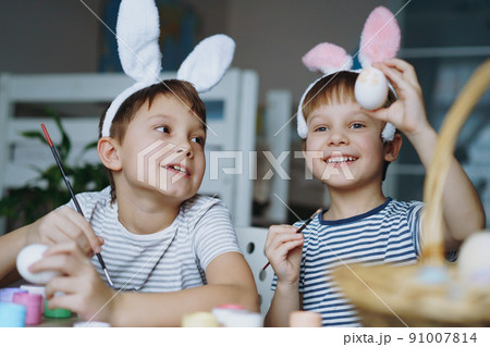 Cute little boys colouring eggs for easter Cute little boys colouring eggs for easter 91007814