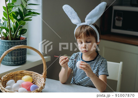 Cute little boy colouring eggs for easter 91007870