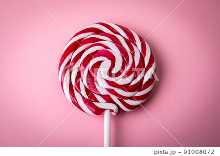 Red and white lollipop on a pink background Red and white lollipop on a pink background 91008072