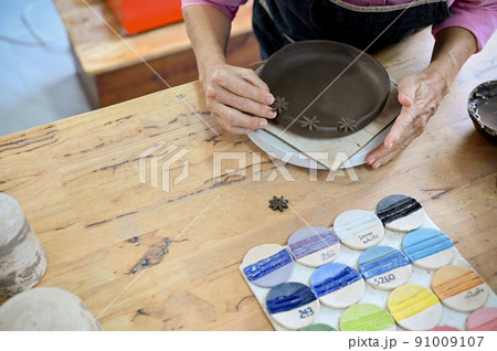 Top view, Professional asian aged woman making a ceramic plate 91009107