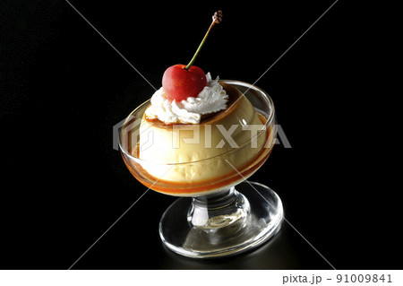サンデーカップに盛り付けてある生クリーム、チェリーの乗った昔ながらのレトロプリンを黒背景で撮影 サンデーカップに盛り付けてある生クリーム、チェリーの乗った昔ながらのレトロプリンを黒背景で撮影 91009841