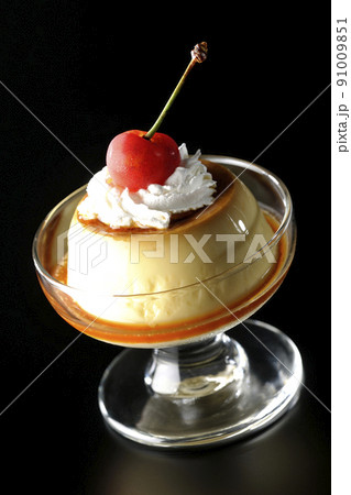 サンデーカップに盛り付けてある生クリーム、チェリーの乗った昔ながらのレトロプリンを黒背景で撮影 サンデーカップに盛り付けてある生クリーム、チェリーの乗った昔ながらのレトロプリンを黒背景で撮影 91009851