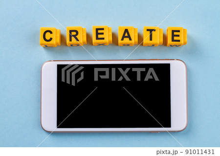 Smartphone with yellow cube lettes with word create. 91011431