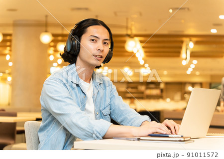 黒いヘッドフォンを付けた男性(ノートパソコン 黒いヘッドフォンを付けた男性(ノートパソコン 91011572