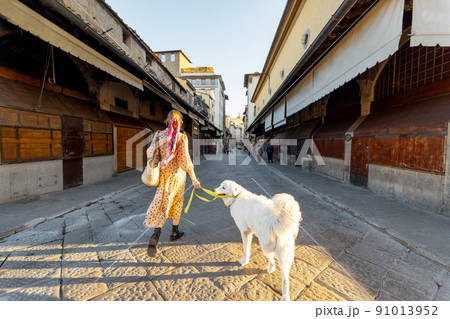 Woman walks on the Old bridge in Florence, Italy Woman walks on the Old bridge in Florence, Italy 91013952