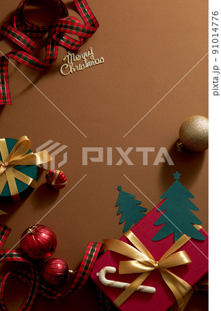 Brown background with colorful christmas ornament decoration , red gift box and ribbon with candy for holiday , top view with blank space for holiday advertising 91014776