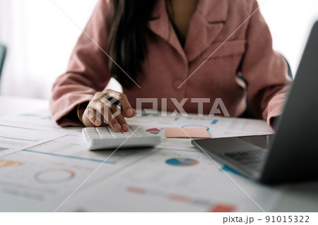 Business woman using calculator for do math finance on wooden desk in office and business working background, tax, accounting, statistics and analytic research concept Business woman using calculator for do math finance on wooden desk in office and business working background, tax, accounting, statistics and analytic research concept 91015322
