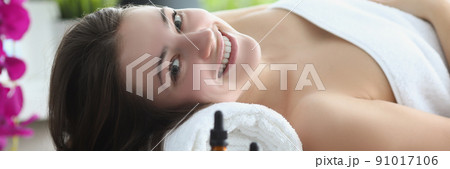 Smiling happy woman laying covered with towels in luxury spa centre 91017106