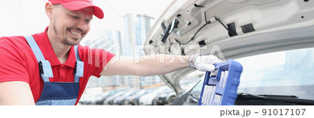 Automotive technician smiling and open kit full of equipments 91017107