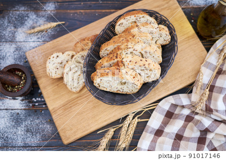 Fresh sliced bread on wooden cutting board at kitchen table Fresh sliced bread on wooden cutting board at kitchen table 91017146