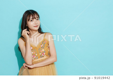 リゾートファッションをした若い女性の青背景のポートレート リゾートファッションをした若い女性の青背景のポートレート 91019442
