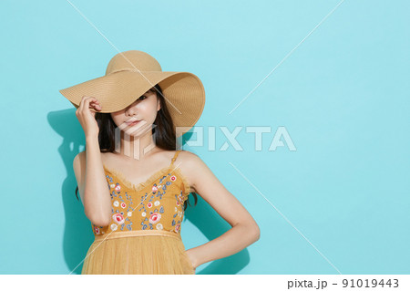 リゾートファッションをした若い女性の青背景のポートレート リゾートファッションをした若い女性の青背景のポートレート 91019443