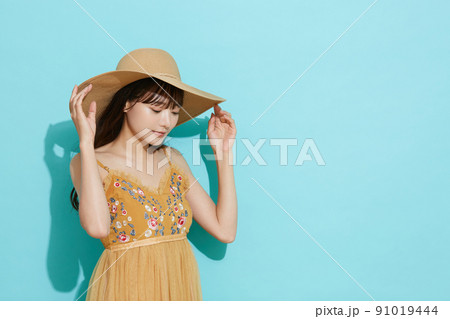 リゾートファッションをした若い女性の青背景のポートレート リゾートファッションをした若い女性の青背景のポートレート 91019444