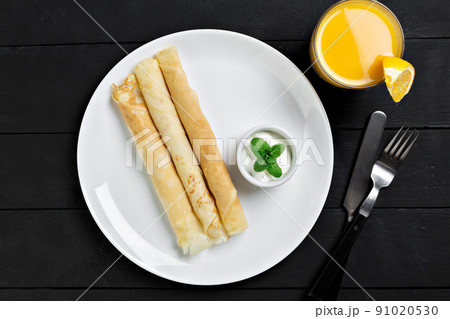 Russian pancakes served in rolls with sour cream Russian pancakes served in rolls with sour cream 91020530