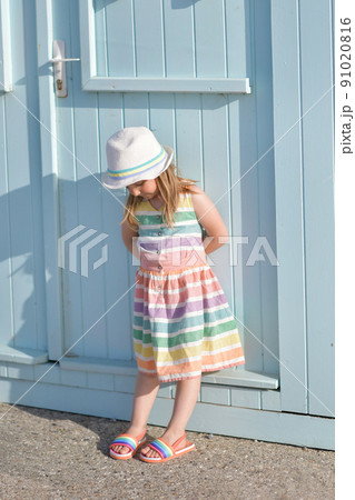 Girl in a colored dress near colorful wooden houses on the ocean Saint aubin sur mer 91020816