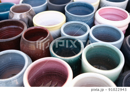 Empty colourful ceramic flower pots in greenhouse or hothouse Empty colourful ceramic flower pots in greenhouse or hothouse 91022943