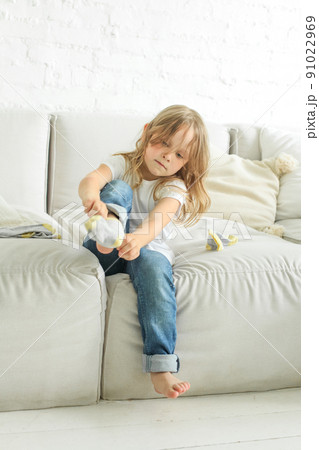 Cute child girl putting on a sock at home Cute child girl putting on a sock at home 91022969