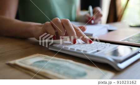 Woman doing calculation of expenses and income and making notes 91023162