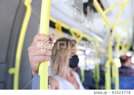 Woman hand holding handrail in tram or bus 91023778