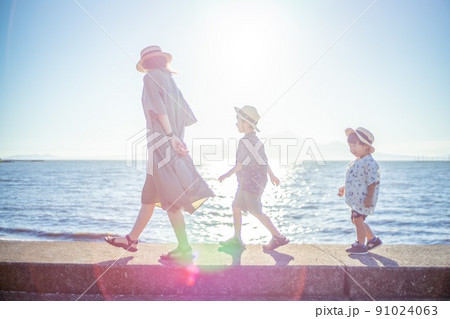 海岸沿いを仲良く歩く親子 91024063