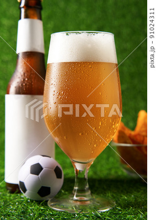 Bottle and glass of beer on the green grass background. Bottle and glass of beer on the green grass background. 91024311
