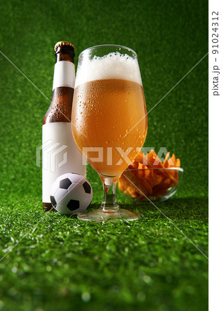 Bottle and glass of beer on the green grass background. Bottle and glass of beer on the green grass background. 91024312
