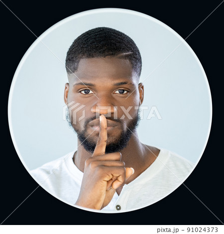 Shush gesture. Keep quiet. Do not disturb. User avatar. Mysterious handsome man portrait with shh finger at lips isolated on light background in black circle frame. Shush gesture. Keep quiet. Do not disturb. User avatar. Mysterious handsome man portrait with shh finger at lips isolated on light background in black circle frame. 91024373