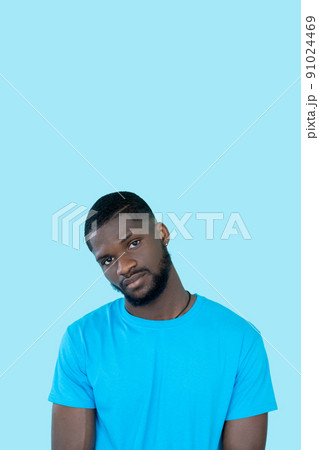 Serious guy. Studio portrait. Skeptic expression. Flyer design. Handsome young beardy careless man isolated on blue copy space background. 91024469